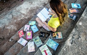 Para todos que amam os livros, blogueira Winny Fernanda com seus livros ao redor.
