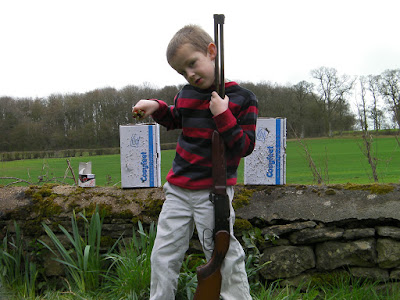 boy with 410 shotgun and destroyed cardboard boxes