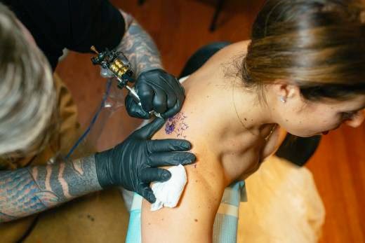 como sombrear un tatuaje tatuador tatuando a mujer joven,