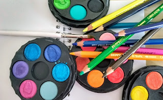 Aquarelverf en -potlood, penseel en klein schetsboekje.