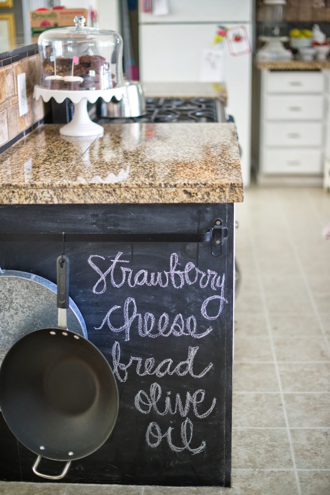 Side of kitchen counter chalkboard wall and kitchen storage.
