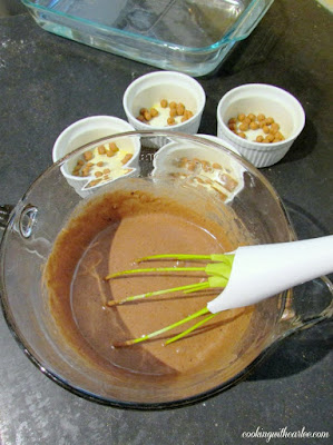mixing bowl of baked chocolate pudding batter next to greased ramekins with caramel bits inside