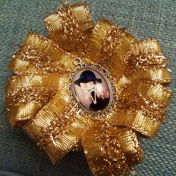 Finished rosette with cameo centre Framed kawaii cameo girl in centre of gold ribbon rosette