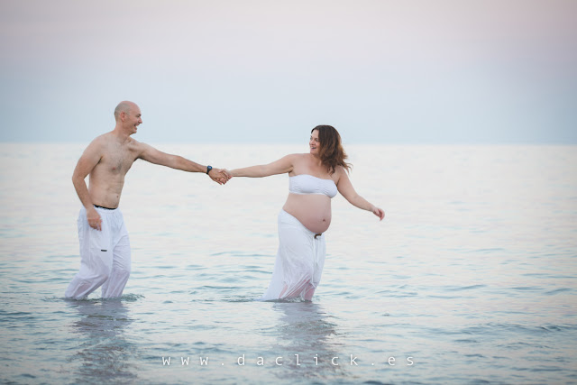 embarazada con su pareja en la playa