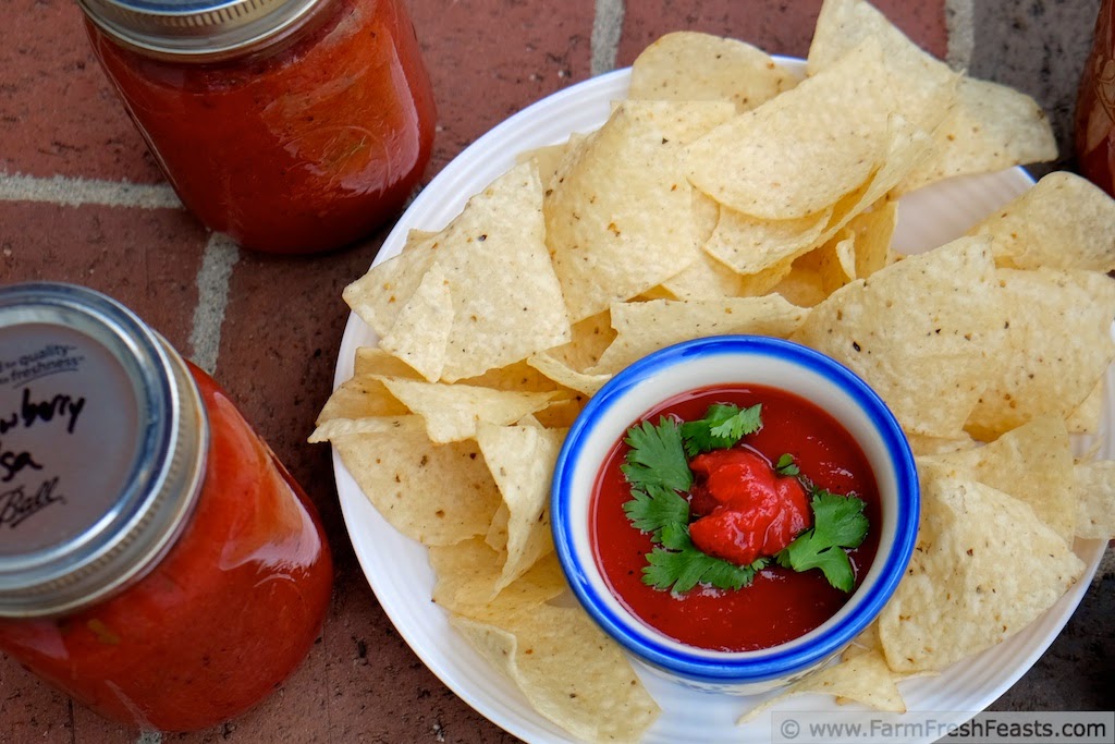 strawberry salsa with chips and canning jars of canned strawberry salsa