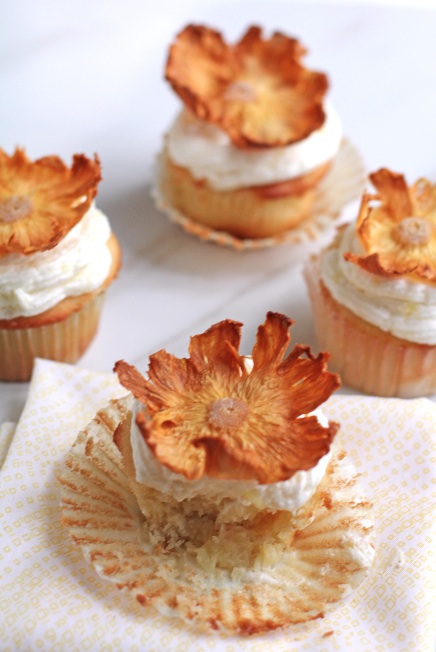Pineapple upside down cupcakes topped with dried flowers.