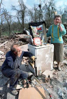 Radenko, left, and Mileka Prtenyakovic, cry in what remains of their home in the city of Chachak