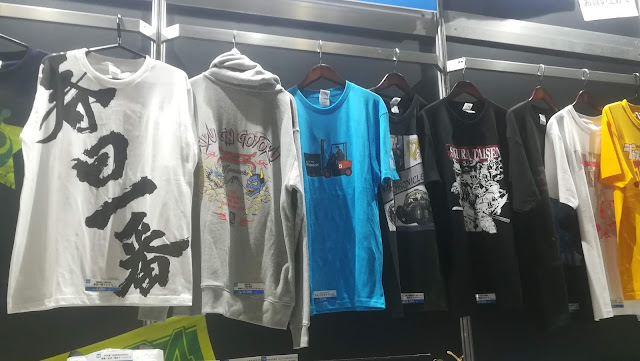 The new-release Shenmue T-shirt (center) with a picture of Ryo driving a forklift.