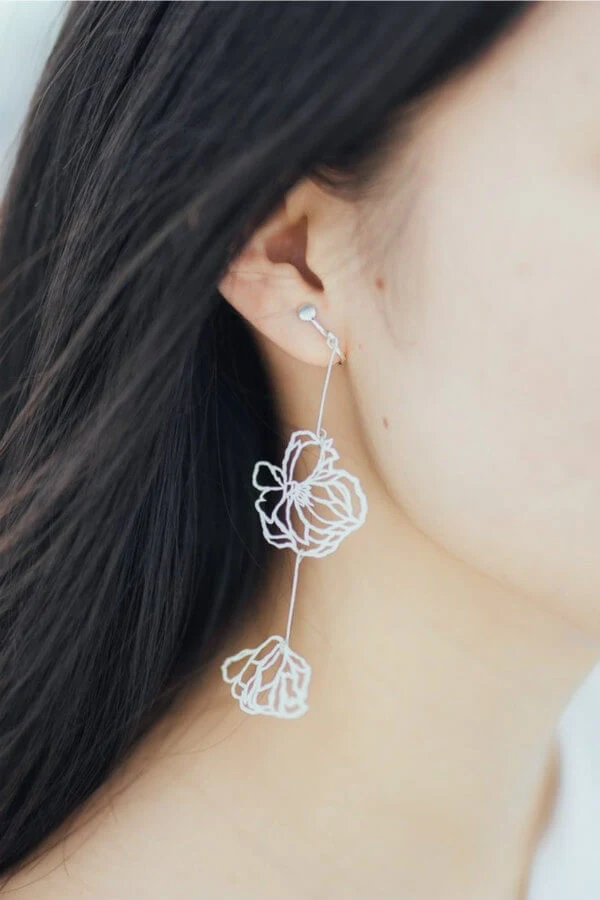 paper cut white floral drop earrings on model
