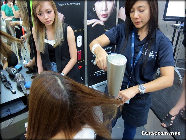 The left half of her hair being blown dry with a conventional hair dyer while the right side was blown dry with Sharp's Plasmacluster Hair Conditioning Dryer