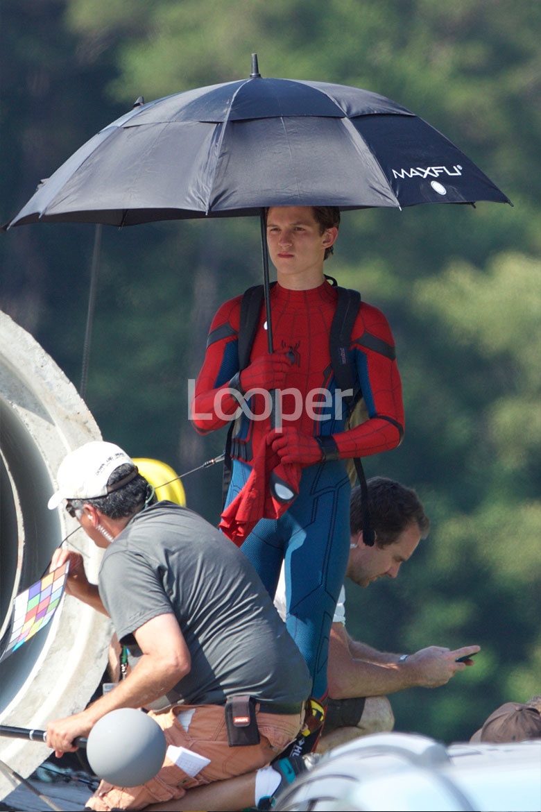 Том прячется от солнца под зонтом