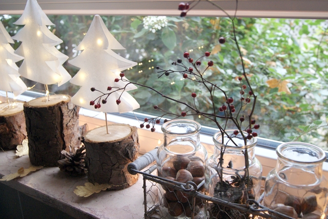 Weihnachtsdeko Fensterbank Papierbäume und Gläser mit Nüssen