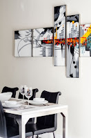 Table with black chairs, empty glasses and plates. Wall art with colors.