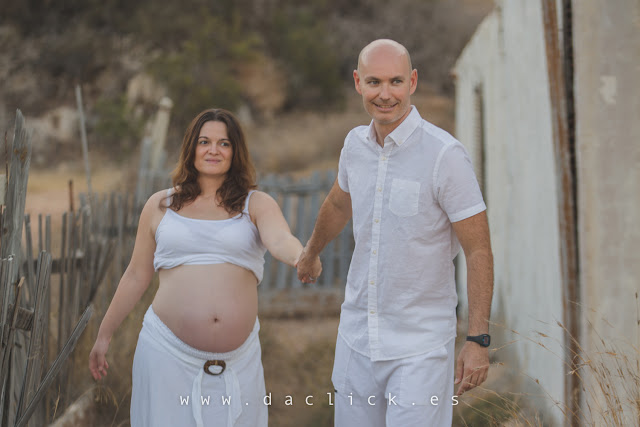 pareja embarazada frente una casa antigua