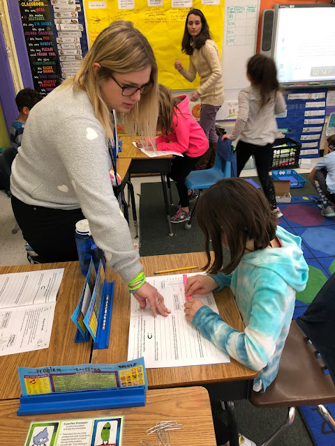 teacher helping student at desk