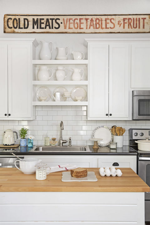 Kitchen Charming cottage style in a farmhouse kitchen with subway tile, white cabinets, and vintage wood sign. #kitchen #cottage #farmhouse #vintagestyle #subwaytile