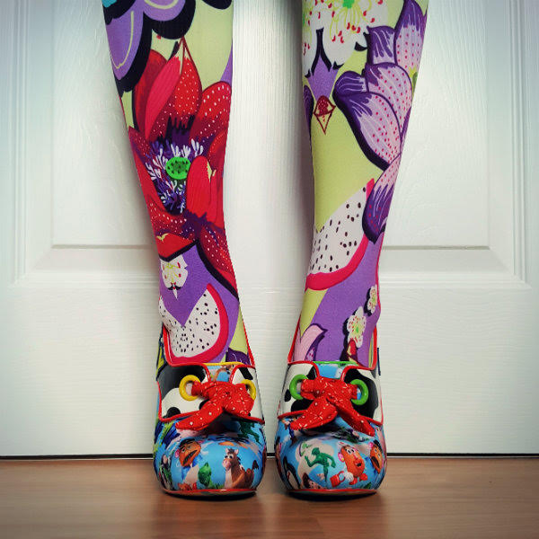 Irregular Choice You've Got A Friend In Me shoes front legs facing forward in bright floral tights with Toy Story patterned shoes