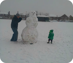 giant snowman, playing with snowman, father and son in snow