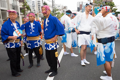 Men from different dance teams wait for the 60th Koenji Awa-Odori Parade to begin. Participants from different groups wait for the 60th Koenji Awa-Odori Parade to start.