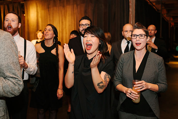 Wedding guests cheer for the brides' first dance. Photo by Julie Harmsen. guests cheer