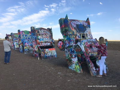 visitor working with spray can at Cadillac Ranch in Amarillo, Texas