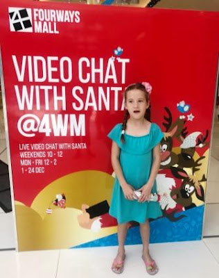 Video Chat with Santa - Fourways Mall Girl in front of banner: Video Chat with Santa