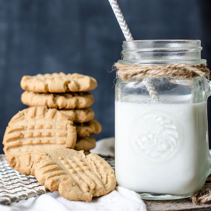 The perfect recipe for peanut butter cookies that are soft, chewy, and full of flavor. Get the recipe at www.andersonandgrant.com Stack of peanut butter cookies and milk
