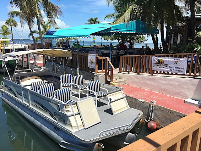 An empty tour boat in the water in front of the restaurant. 