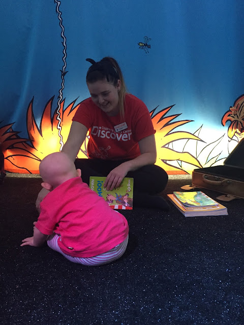One of the Story Builders at Discover Stratford in the toddler Dr Seuss session with a baby sitting in front of her