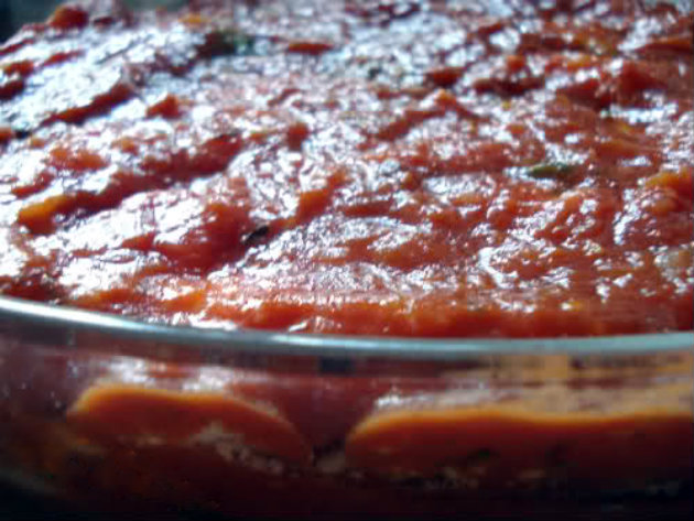 Finish with a layer of tomato sauce to completely cover the eggplant.