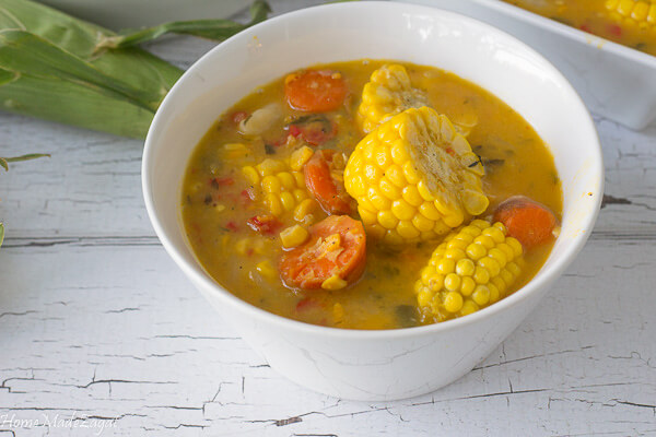 A bowl of delicious corn soup with corn carrots and dumplings
