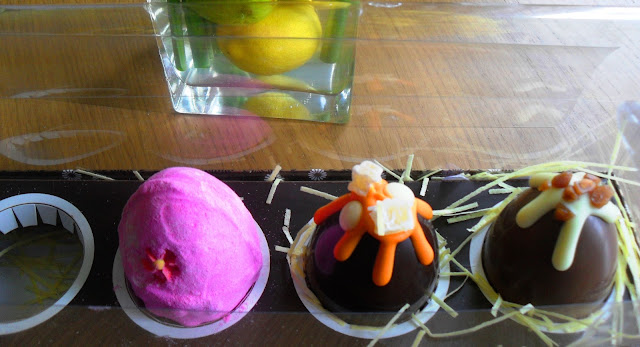 Lush pink fluffy egg sat in a row with chocolate easter eggs