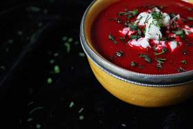 A thick red soup with fresh herbs and cheese