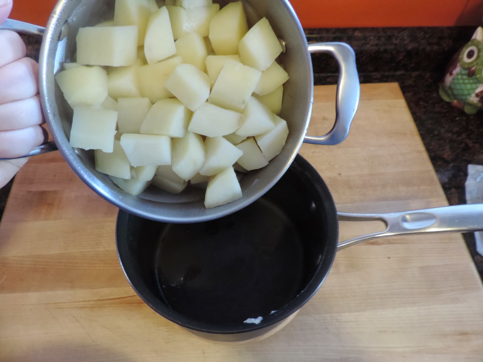 The cooked potatoes being added back into the pot. 