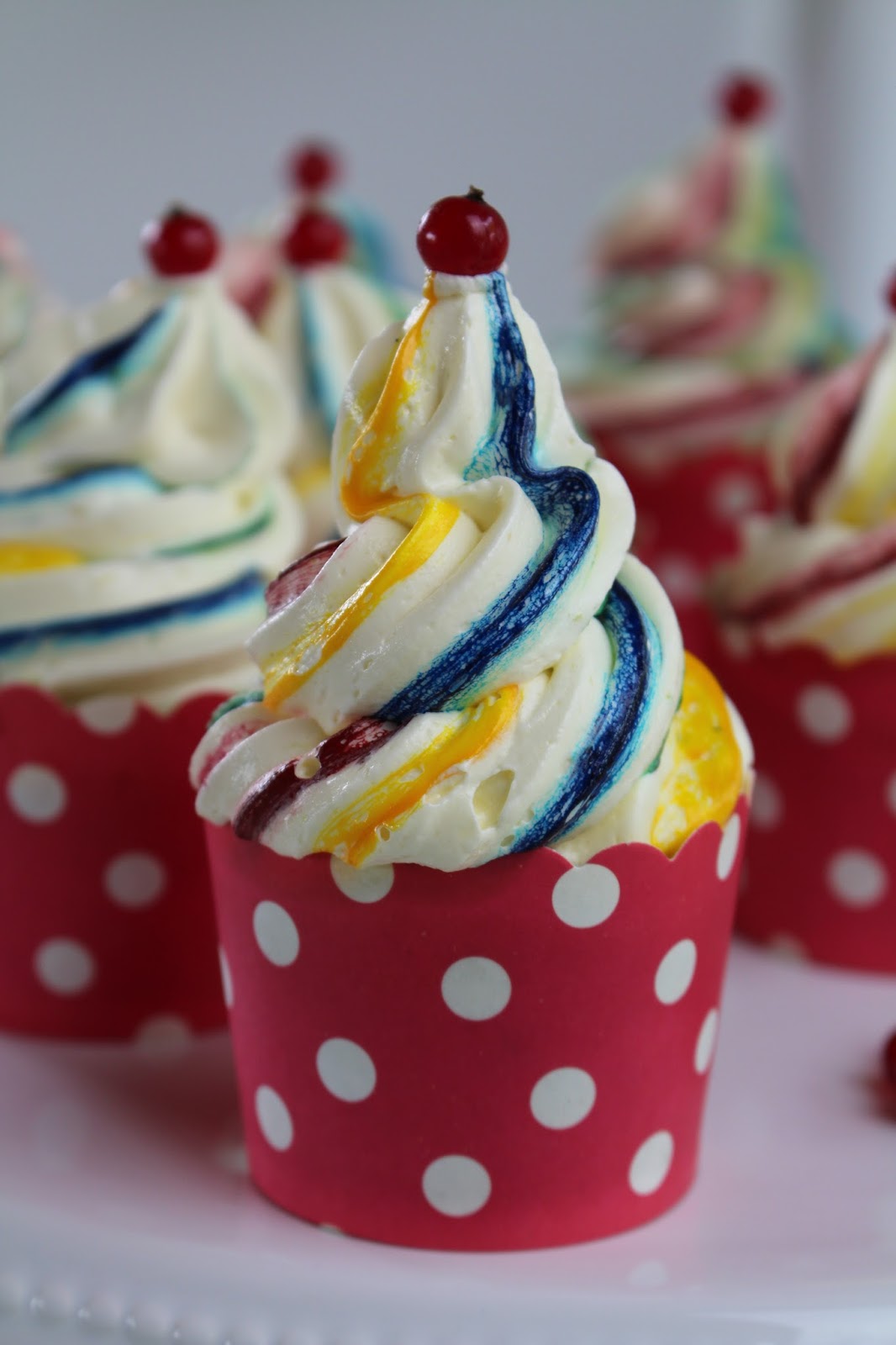 Zitrone-Mohn-Himbeeren-Cupcakes mit Regenbogen-Frosting