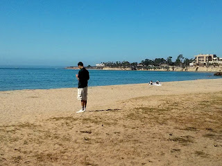 Young man standing on a beach facing the ocean of life's choices