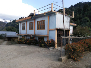 Longsha homestay cement building for tourists situated opposite main Wangnao ancestral konyak hut.