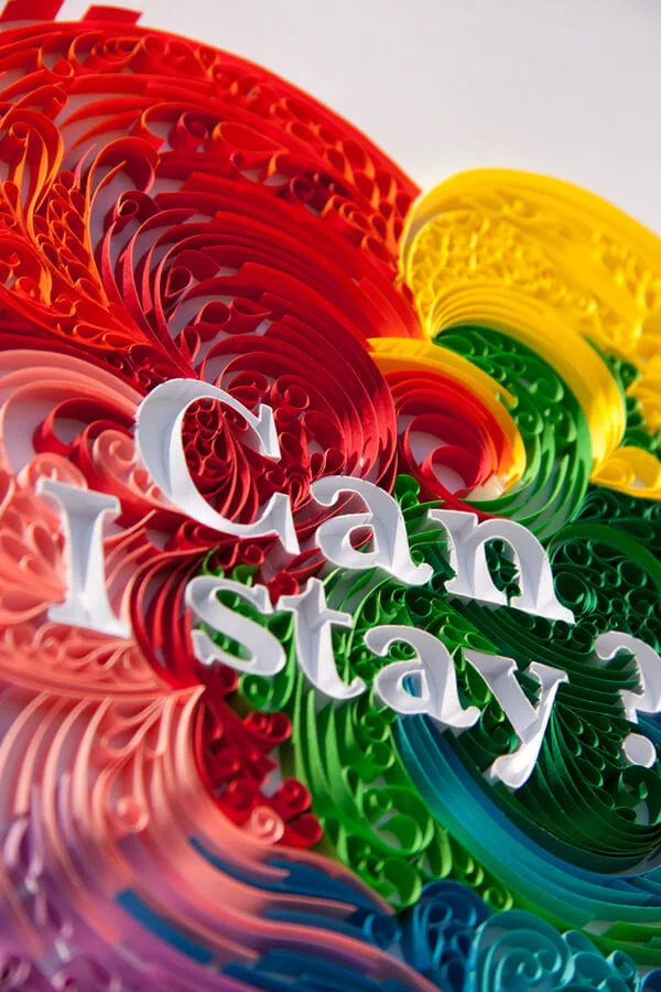 White lettering surrounded by colorful quilling