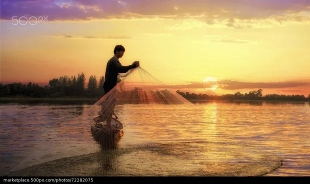 Homem pescando e sol nascendo