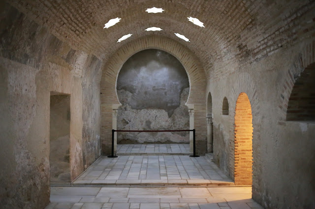 Interior de baño árabe con arcos orientales y tragaluces de estrellas.