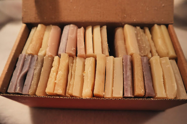 A cardboard box containing two rows of soap offcuts, packed tightly together. 