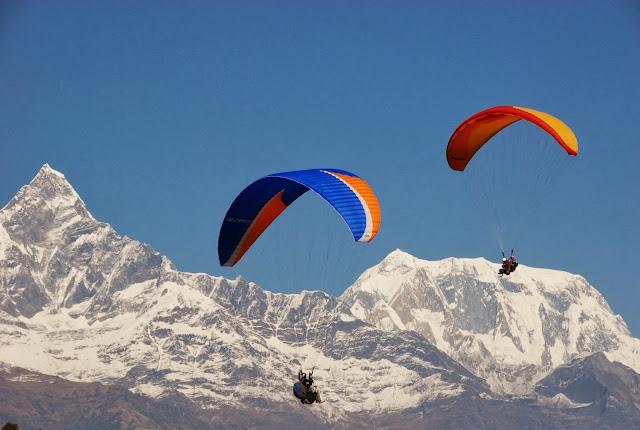 Twee paragliders in de bergen Achtergrond met paragliders die boven de bergen zweven