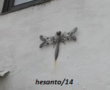 escultura de libélula em parede de casa