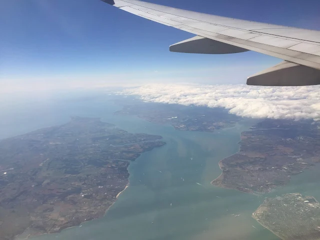 A view out of an aeroplane window showing see and islands