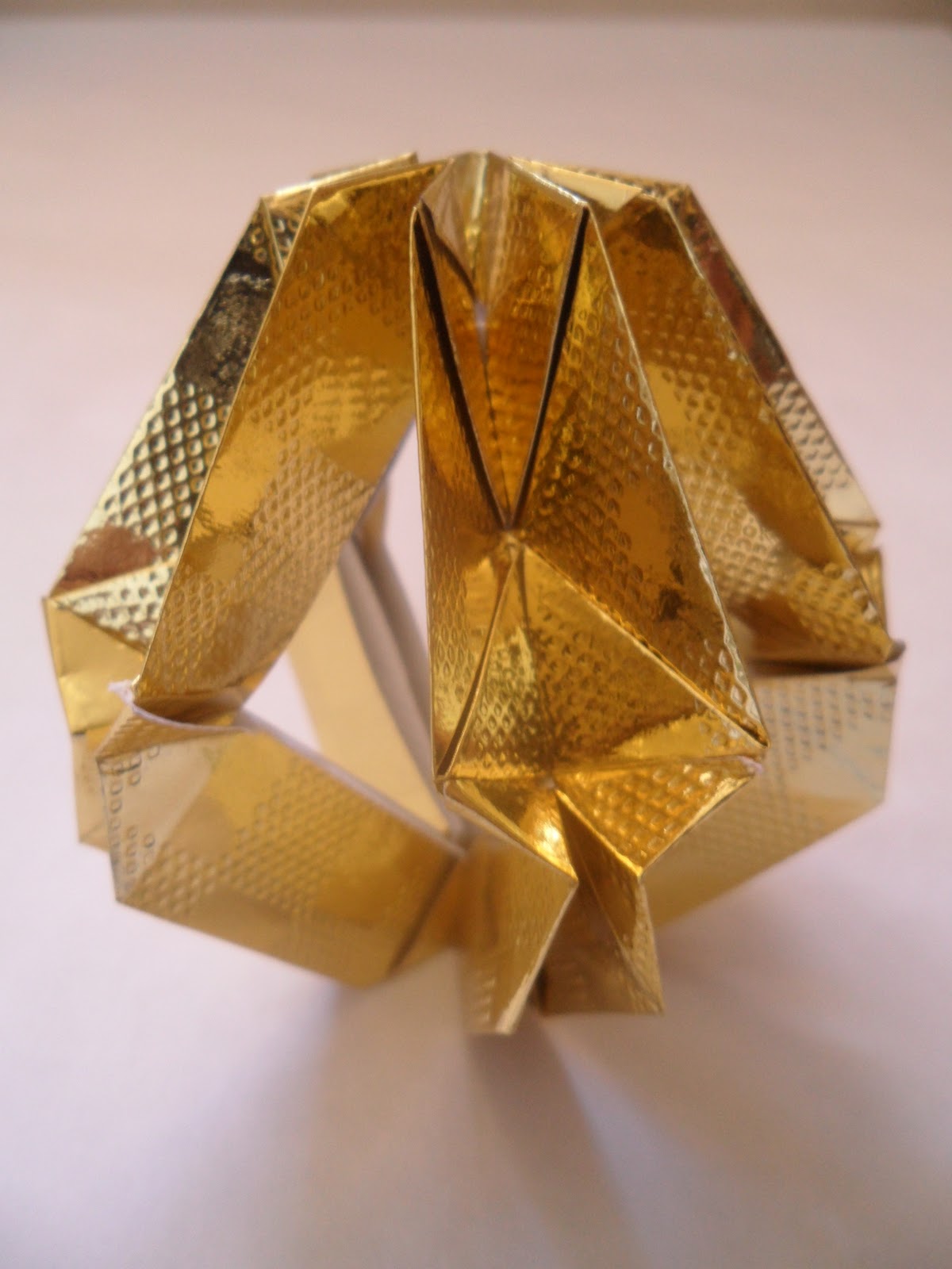 Peça vazada de origami dourado
