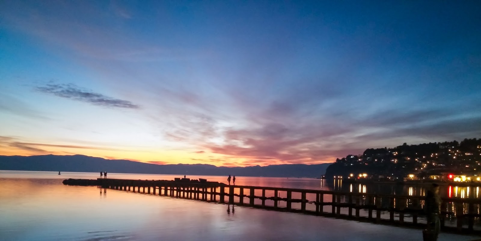Sunset, dock on lake shores in the night