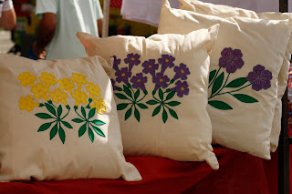 Capas de almofada com flores de ipê aplicadas. Ana Lúcia Fontes