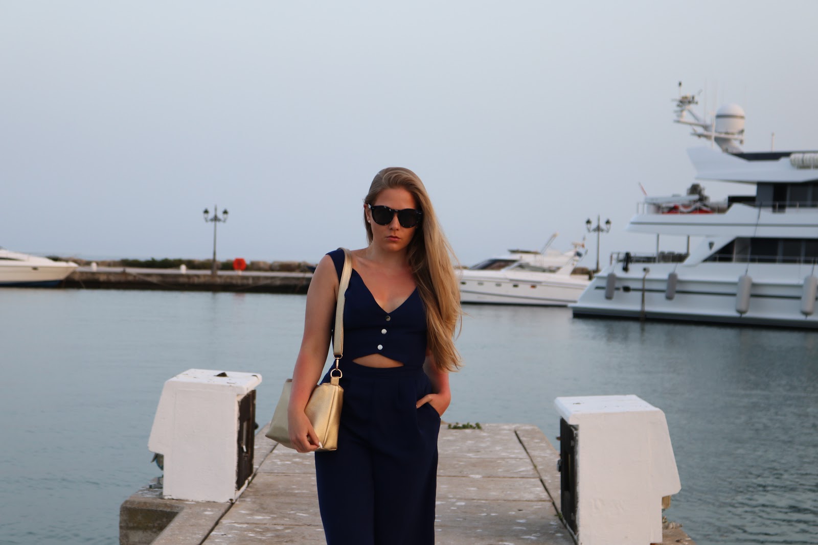 Blonde girl wearing Little Mistress blue jumpsuit, in the Sotogrande Puerto, Spain
