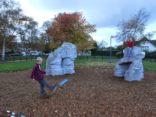 boy chip - kicking football at friend on climbing rock milton park southsea in the rain