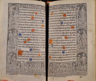 An open page of printed text with decorated initials. There is a printed ornamental border around the text.